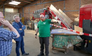 Dominik Sträßer, Mitarbeiter des Holzenergiehofes, präsentiert Besuchern den Maschinenpark des Holzenergiehofes
